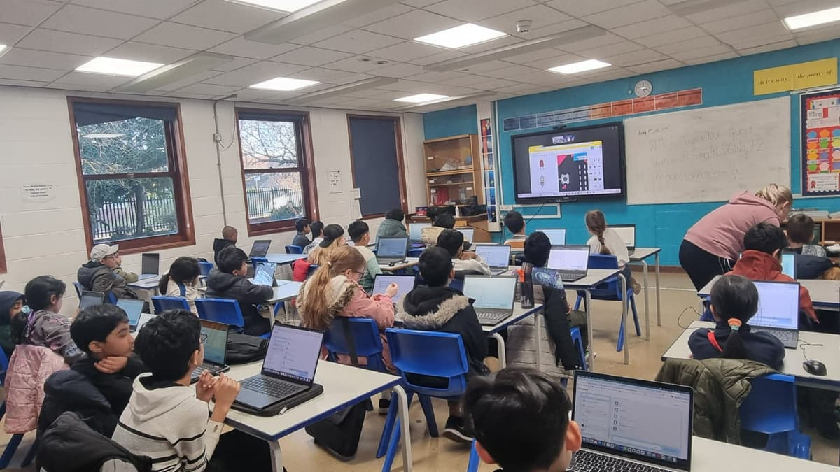 Students engaged in a live MathShotJr classroom session with laptops